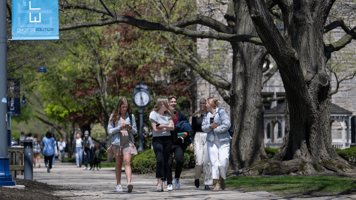 Students walk down a sidewalk on Butler's campus